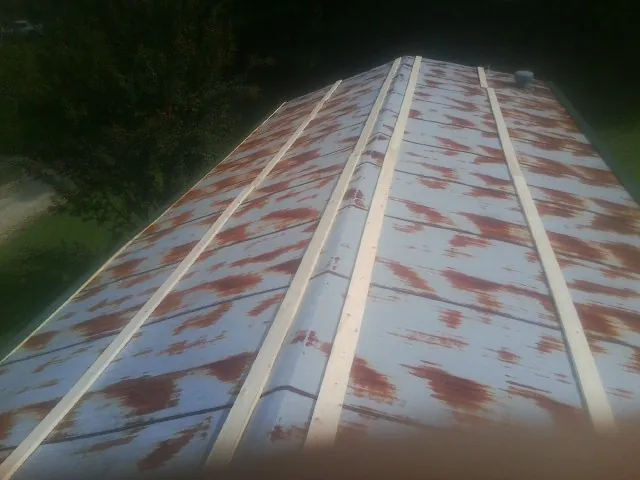 Rusted metal roof panels with new wood purlins before replacement — Storm Damage Roof Repair in Andrews by Roofing Brothers