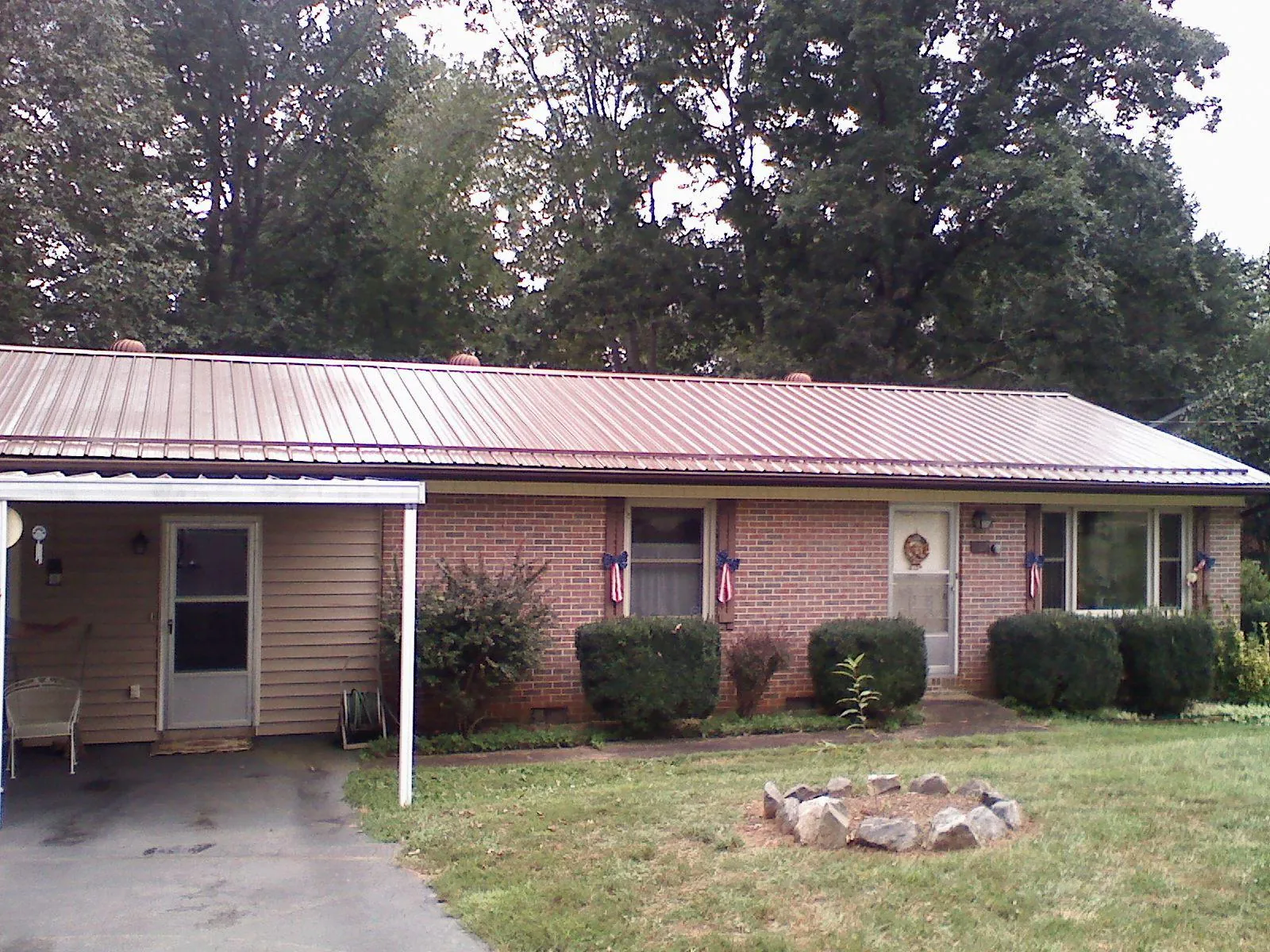 Bronze metal roof and carport on a brick ranch home — Roof Repair work by our crew in Andrews