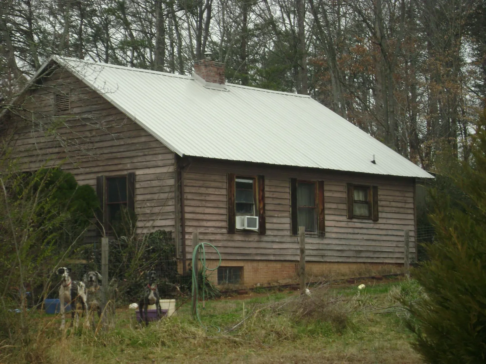 White metal roof on an old wood sided farmhouse, from a Metal Roof Installation job in Andrews